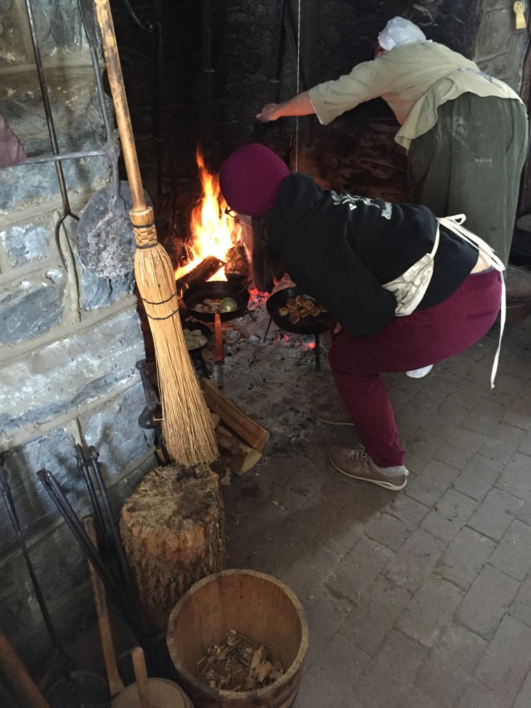 Nicole flipping meat balls over an open hearth (a 1930s-era reconstruction) at Landis Valley, February 2015