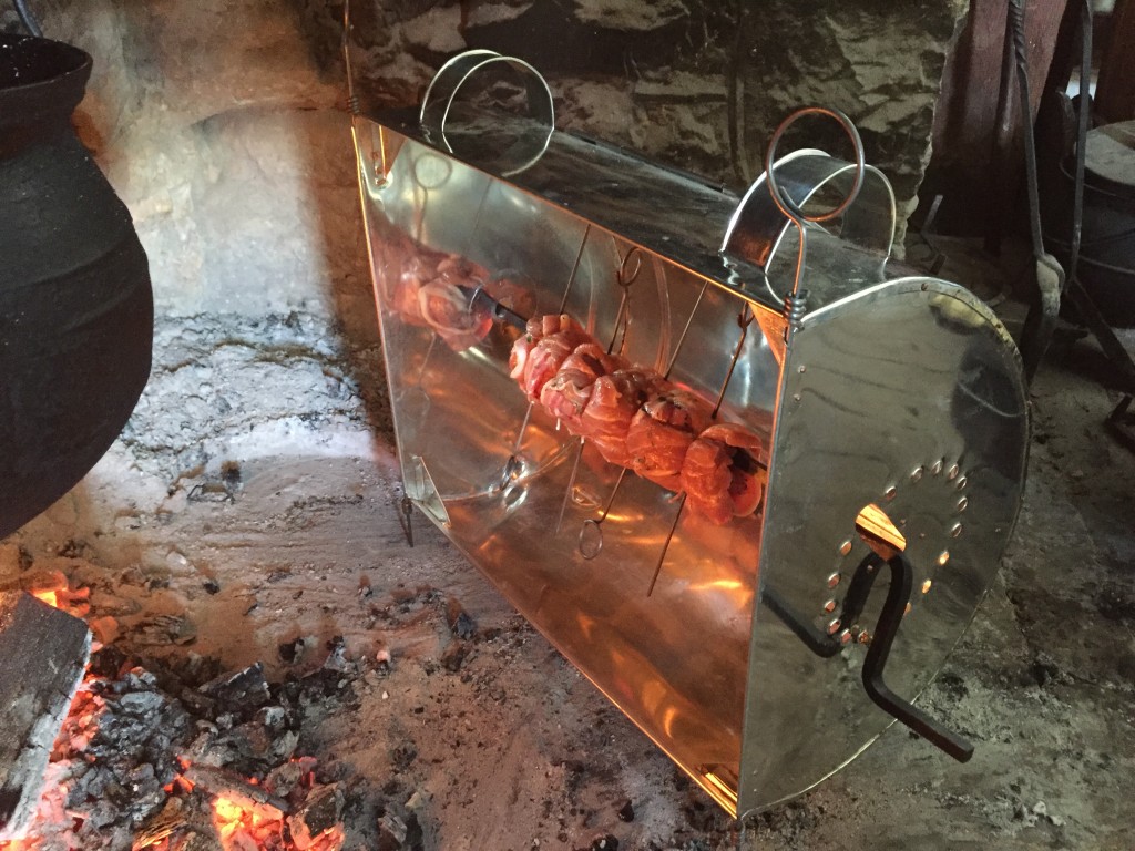 Roasting pork-wrapped bacon in a reflector over at Landis Valley, February 2015